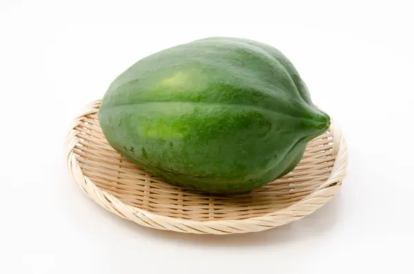 Green Papaya Een Bamboe Zeef Witte Achtergrond — Stockfoto