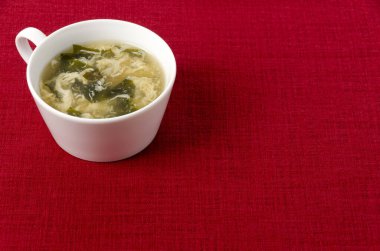 wakame yosun yumurtası çorbası kırmızı bez arka planda..