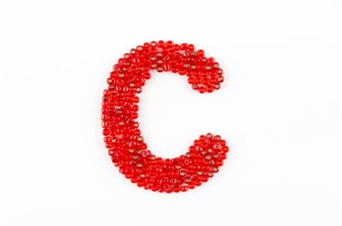 Beyaz zemin üzerinde kırmızı boncuklar alfabesi C