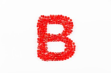 Beyaz zemin üzerinde kırmızı boncuklar alfabesi B