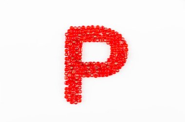 Beyaz zemin üzerinde kırmızı boncuklar alfabesi P