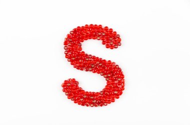 Beyaz zemin üzerinde kırmızı boncuklar alfabesi S