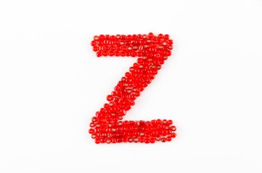 Beyaz zemin üzerinde kırmızı boncuklar alfabesi