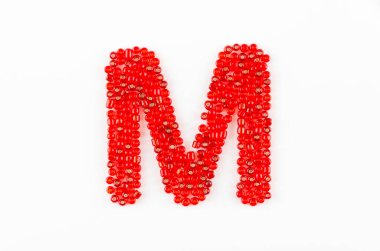 Beyaz arkaplanda kırmızı boncukların alfabesi M