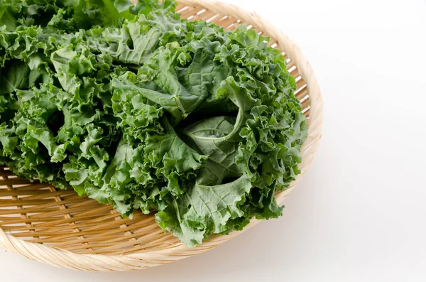Fresh Curly green kale on bamboo sieve on white background