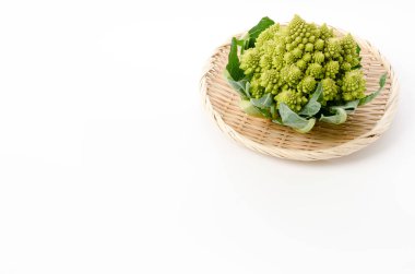 Beyaz arka planda bambu elek üzerine taze sebze brokoli.
