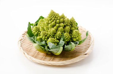 Beyaz arka planda bambu elek üzerine taze sebze brokoli.