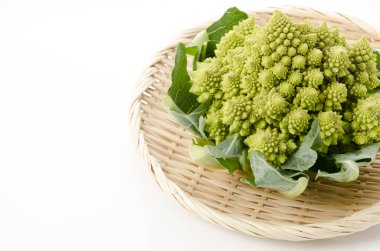 Beyaz arka planda bambu elek üzerine taze sebze brokoli.