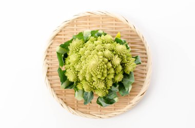 Beyaz arka planda bambu elek üzerine taze sebze brokoli.