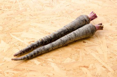 Tahta arka planda siyah havuç