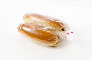Beyaz arka planda plastik torbada sosisli sandviç.