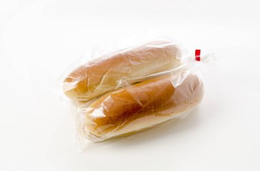 Beyaz arka planda plastik torbada sosisli sandviç.