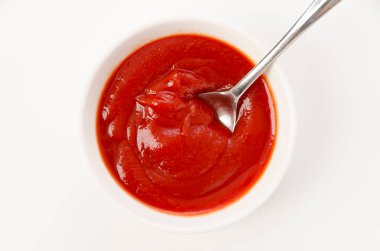 Beyaz arka planda beyaz bir kasede domates ketçapı