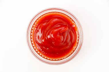 Beyaz arka planda küçük bir cam kasede domates ketçapı.