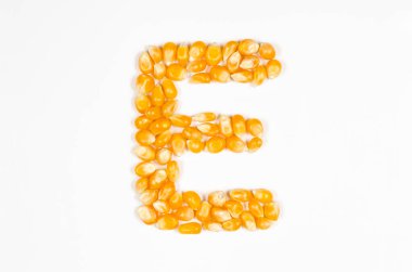 Beyaz zemin üzerinde kuru patlamış mısır tohumlarından İngiliz alfabesinin E harfi.