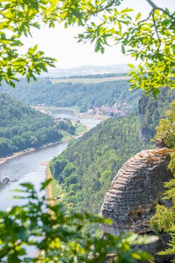 Dresden ve Elbe nehri kıyısındaki Saksonya, Almanya 'nın ulusal parkındaki Kurort Rathen köyü yakınlarındaki Bastei kumtaşı sütunları üzerinde kuş bakışı kapak sayfası.