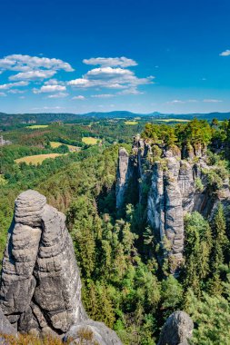 Dresden ve Çek sınırındaki Saksonya, Almanya 'nın Saksonya sınırı yakınlarındaki Sakson İsviçre ulusal parkındaki Kurort Rathen köyü yakınlarındaki anıtsal Bastei kumtaşı sütunları ve antik köprü manzarası