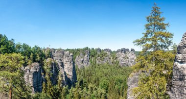 Dresden ve Çek sınırındaki Saksonya, Almanya 'nın Saksonya sınırı yakınlarındaki Sakson İsviçre milli parkındaki Kurort Rathen köyü yakınlarındaki anıtsal Bastei kumtaşı sütunları ve antik köprü üzerindeki panoramik manzara