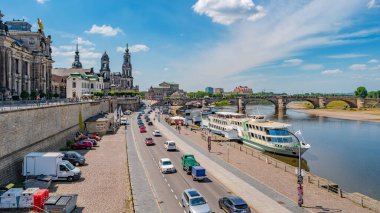 Dresden 'deki tarihi merkez Elbe nehrinin karşısında, kıyısında, pek çok turist ve yerli insan güneşli yaz gününde ve mavi gökyüzünde dinleniyor.