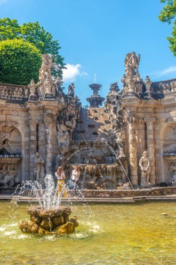 Zwinger Sarayı, bahçeler, heykeller ve fıskiyelerle dolu kapak sayfası. Almanya 'nın Dresden kentindeki tarihi ve müzelerde turistler var.