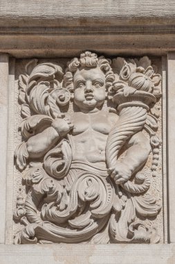 Old relief bar of a small child with Cornucopia, horn of plenty in the historical downtown of Dresden, Germany, details, closeup