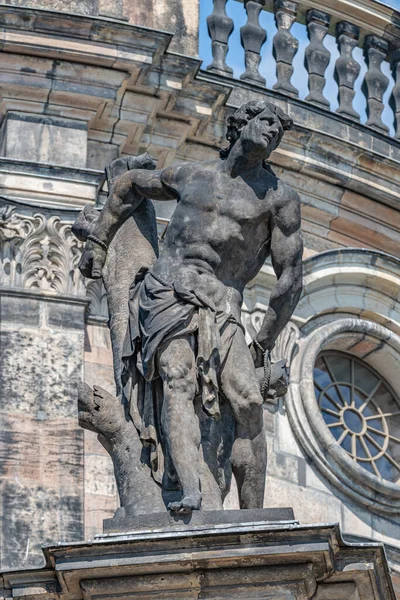 Old statue of a man in slavery in downtown of Dresden, Germany, details, closeup
