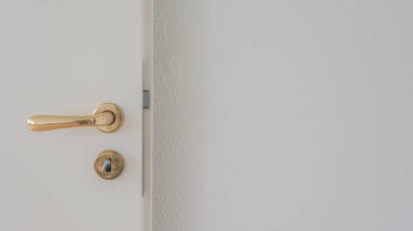 White door with golden doorhandle and key in the locker with blur copy space wall background
