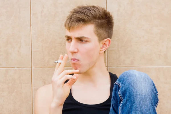 Junger Mann beim Rauchen in Schwierigkeiten — Stockfoto