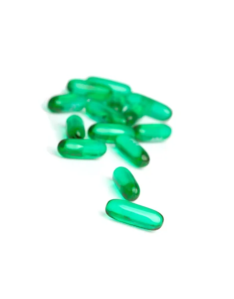 Green capsules on white — Stock Photo, Image