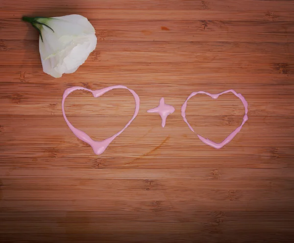Coeurs aimants concept sur bois avec bourgeon de rose — Photo