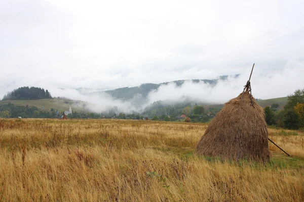 Haystack in the foggy mountains — Stock Photo, Image