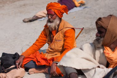 Holy hindu man Sadhu prays on the ground clipart