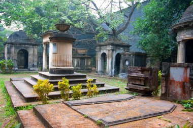 yaşlı ağaçlar ve Asya mezarlıkta eski mezar taşları