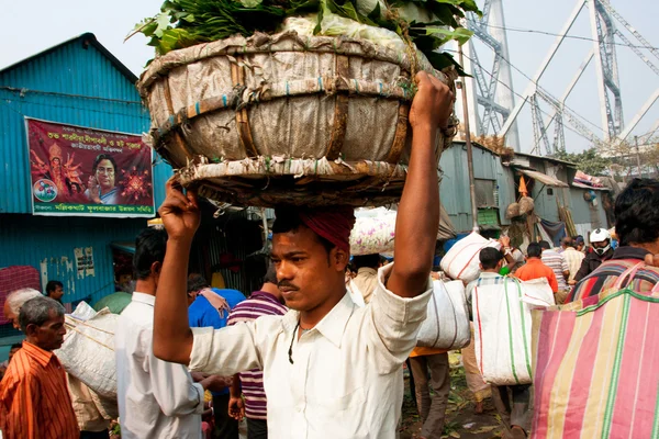 Aziatische werknemer uitgevoerd op de drukke mullik ghat bloemenmarkt — Stockfoto