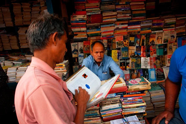 Cliente e comerciante de livros no mercado de rua asiático — Fotografia de Stock