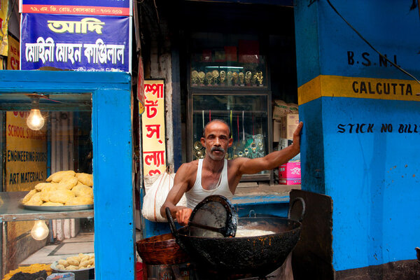 Взрослый азиат готовит простые уличные блюда на открытом воздухе
