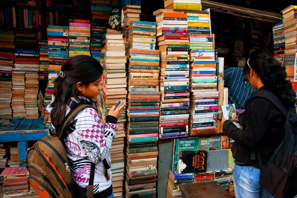 Jovem estudante escolhe o livro no mercado de rua — Fotografia de Stock