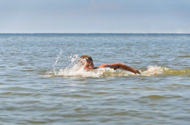 genç erkek denizde yüzmek