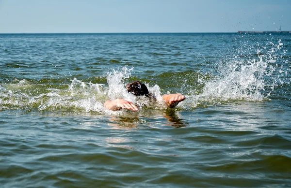 Молодой мужчина плавает в море — стоковое фото