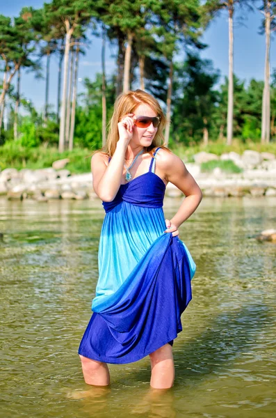 Ładna kobieta w długiej sukni, pozowanie na morzu — Zdjęcie stockowe