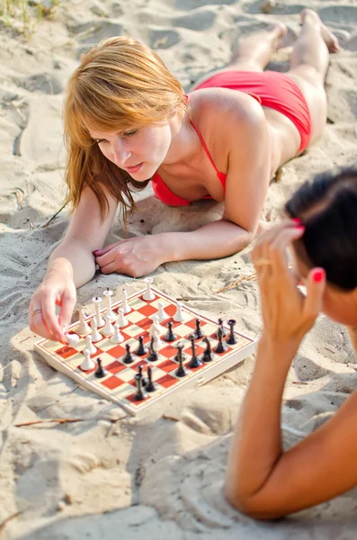 Twee meisjes spelen Schaken op het strand — Stockfoto