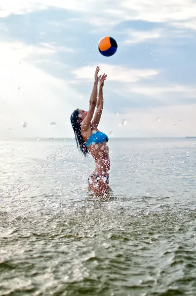 Jovem mulher jogando vôlei no mar — Fotografia de Stock