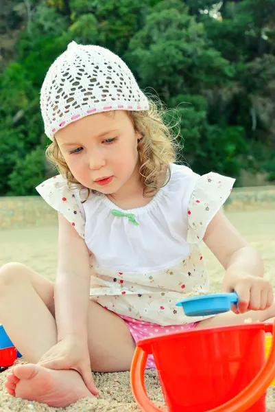 Kleines Mädchen spielt mit Spielzeug am Strand — Stockfoto