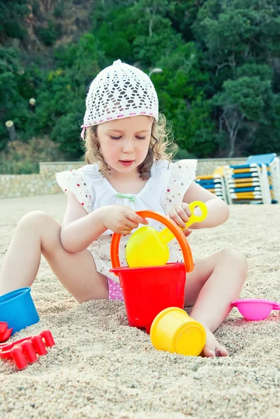 Kleines Mädchen spielt mit Spielzeug am Strand — Stockfoto