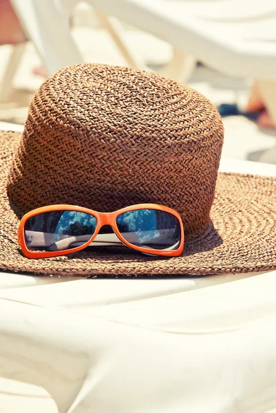 Slaměný klobouk se slunečními brýlemi lehátko — Stock fotografie