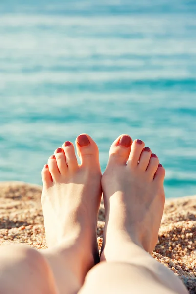 Close-up van vrouwelijke voeten aan zandstrand — Stockfoto