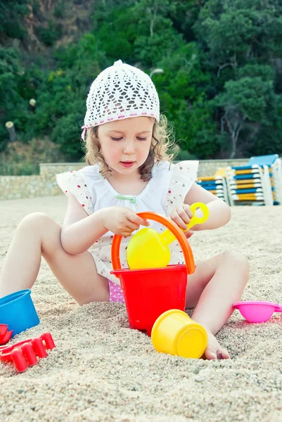 Little girl playing with toys on the beach Stock Photo