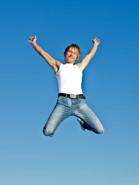 Glücklich springender Mann auf blauem Himmel Hintergrund — Stockfoto