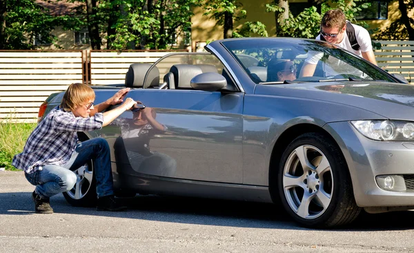 Maschio ladro apertura auto porta mentre il suo complice distrae conducente femminile — Foto Stock