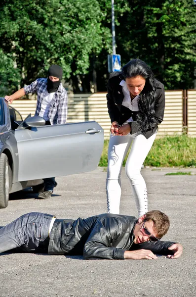 Ladro maschio rubare una macchina mentre il suo complice distrae conducente femminile — Foto Stock